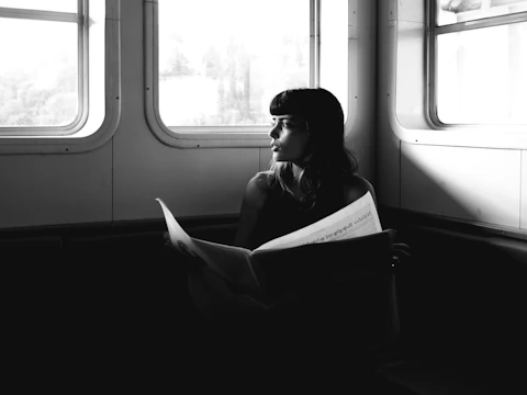 A reader beside a train window